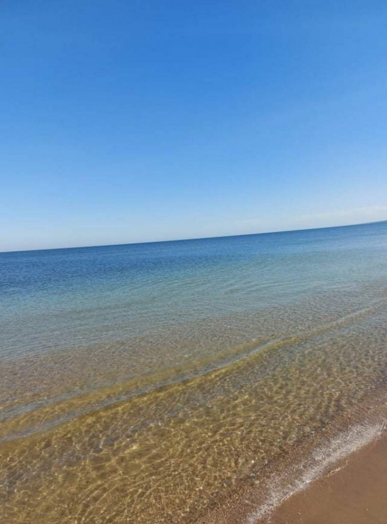 Morze Bałtyckie woda, piasek i bezchmurne niebo. Pogoda słoneczna