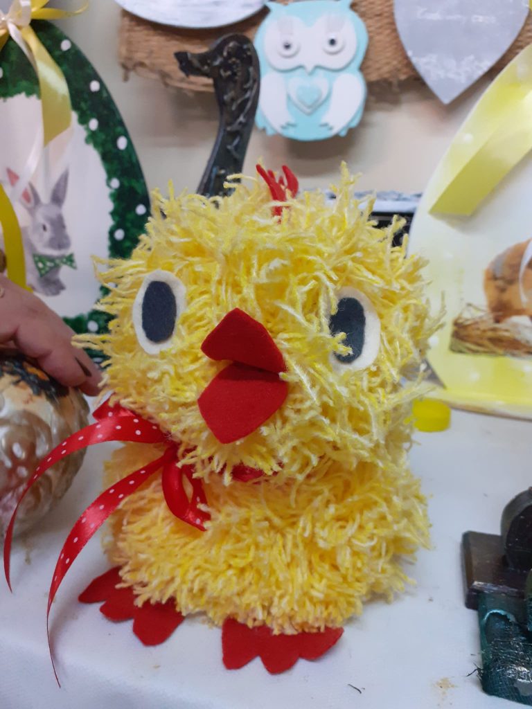 Żółty kurczak z czerwoną wstążeczką i ziobem. Ozdoba wykonana z materiału