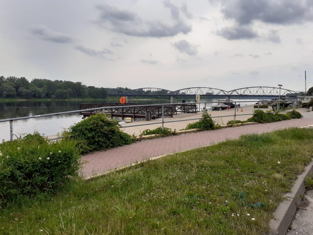 Widok na most w Toruniu (trzy łuki) pod mostem płynie woda.