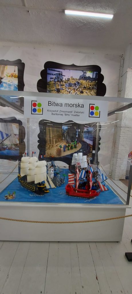 Szklana gablota z makietami z klocków lego przedstawiająca statki z żaglami.