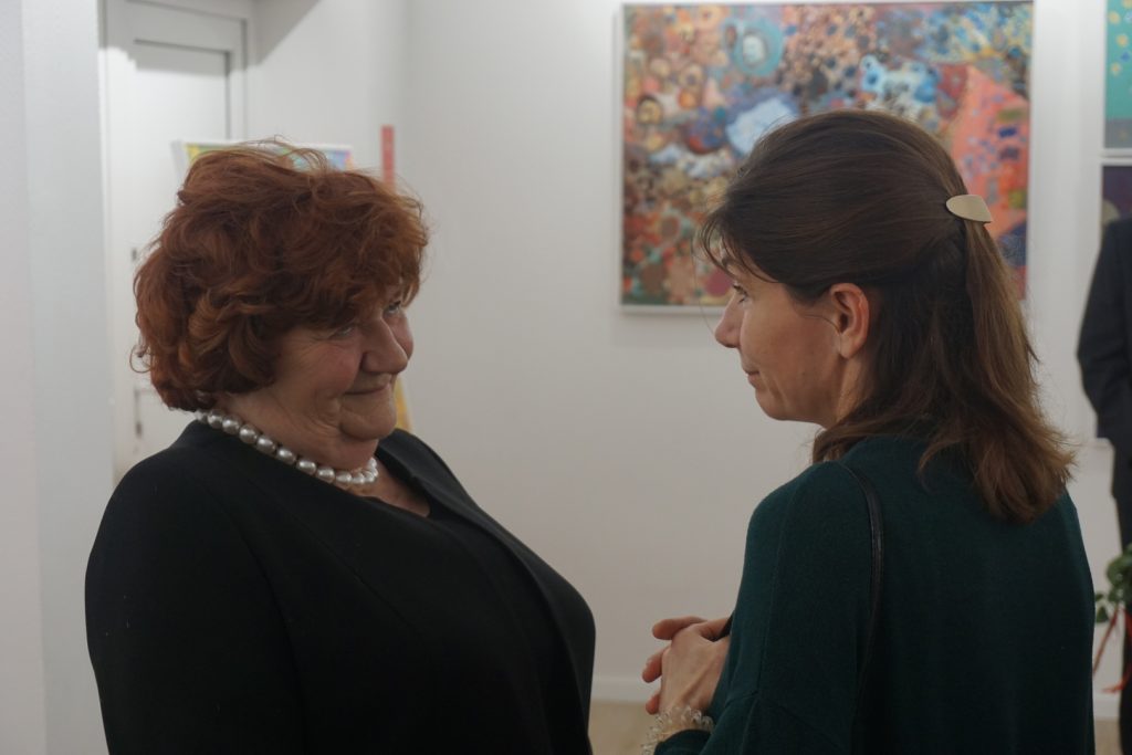 Uśmiechnięta Dyrektor DPS rozmawia z kobietą podczas trwającej wystawy