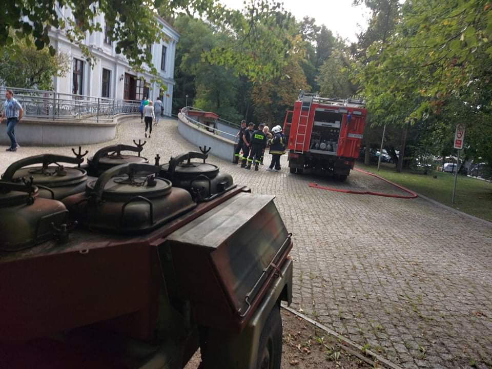 Kuchnia polowa za nią duży wóz strażacki stojący obok siedziby głównej DPS.