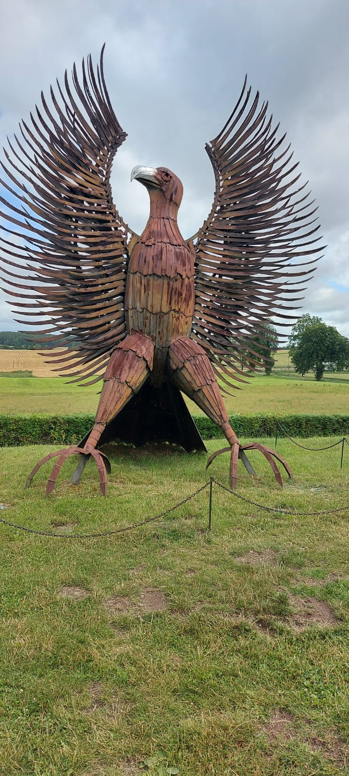 Metalowa rzeźba wysokiego orła z rozpiętymi skrzydłami oraz głową zwróconą ku górze.