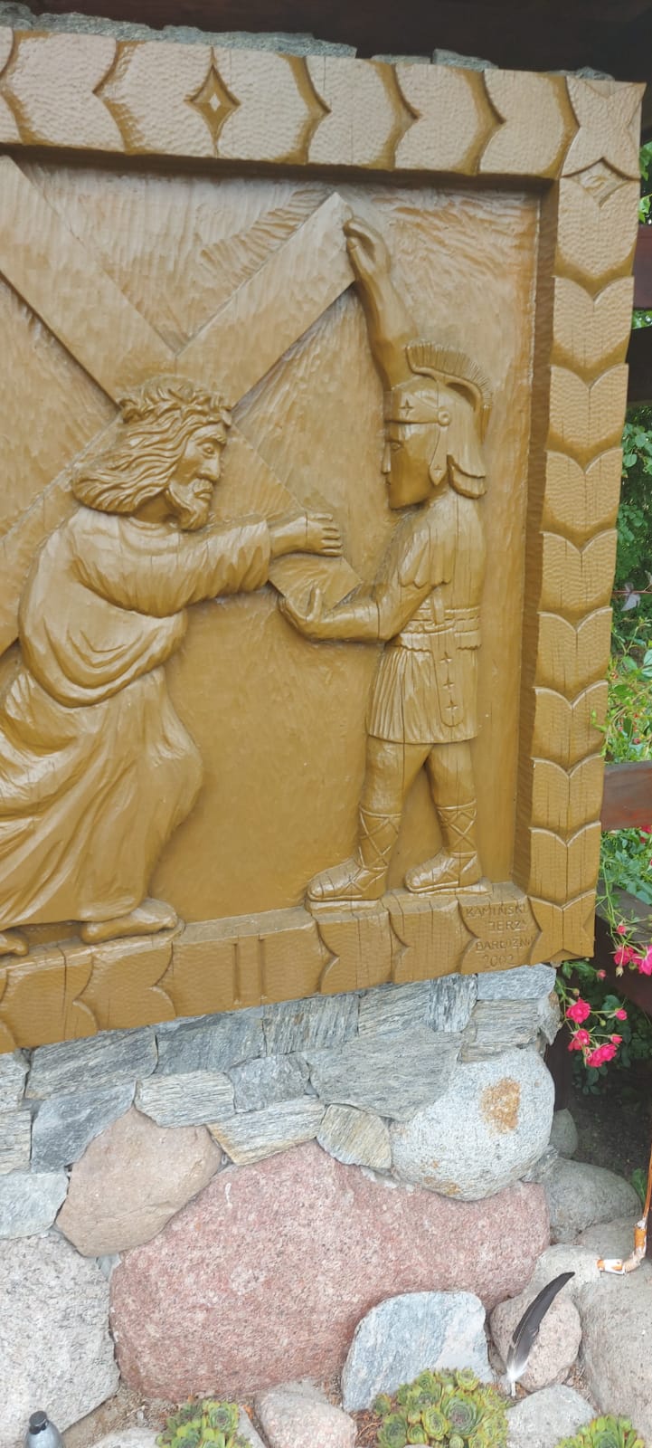 Drewniany obraz Jezusa niosącego krzyż oraz żołnierza przytrzymującego krzyż. Napis na obrazie "II". Autor Jerzy Kamieński Barłożno 2002.